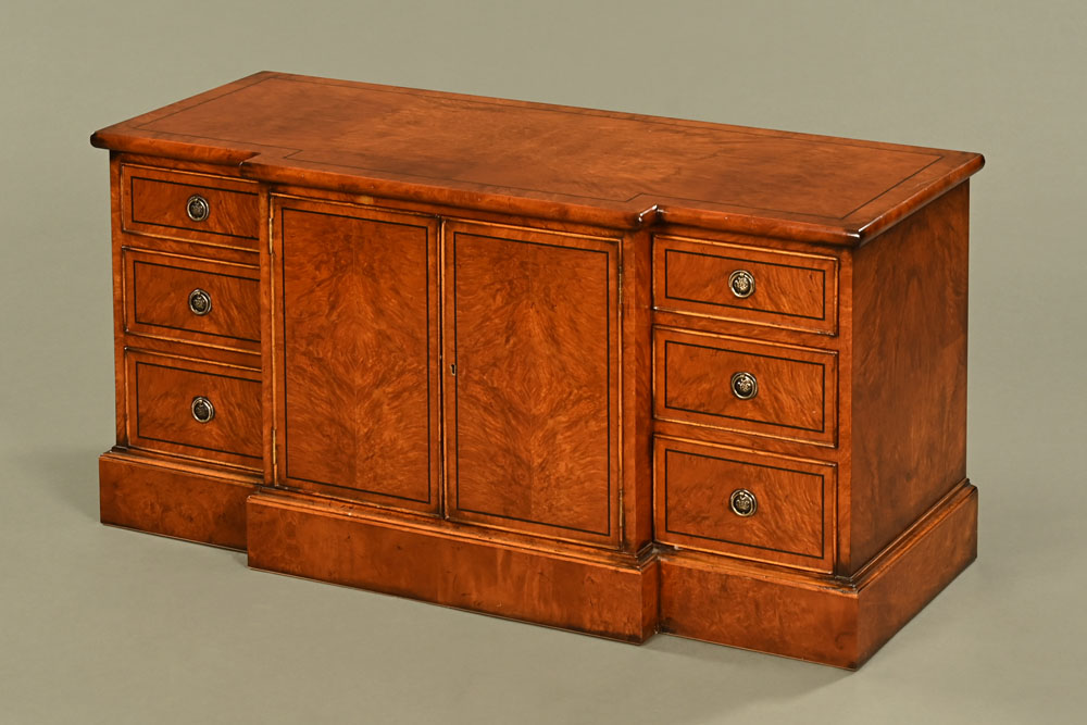 A burr walnut and inlaid low breakfront cabinet, with doors and drawers and raised on a plinth.