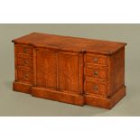 A burr walnut and inlaid low breakfront cabinet, with doors and drawers and raised on a plinth.