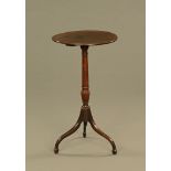 A Georgian mahogany tripod or wine table, raised on tapered spade feet.