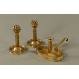 An Arts & Crafts brass chamber stick, together with a pair of ships candlesticks. Tallest 20 cm.