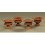 A set of four small cast iron urns, Campana shaped. Height 21 cm, diameter 27 cm.