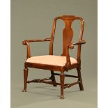 A George II walnut open armchair with bold and unusual scrolled arms.