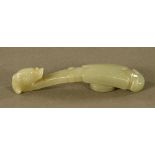 A Chinese carved jade button or belt hook in the form of a Chilong with folded wings. Length 11 cm.
