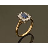An 18 ct gold sapphire and diamond cluster ring. Size M, 3.8 grams.