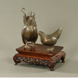 A Japanese bronze cockerel and hen, raised on a wooden base.