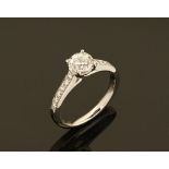 An 18 ct gold diamond shoulder ring, the centre diamond +/- 1 carat.