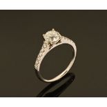 An 18 ct gold diamond ring with diamond set shoulders, the centre diamond +/- 1 carat.