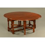 A large oak and crossbanded gate legged dining table,