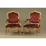 A pair of gilt framed armchairs, with upholstered arms, back and seat and raised on cabriole legs.