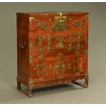 An antique elm Korean cabinet, with brass carrying handles and mounts,