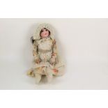 An early 20th century Schoenau and Hoffmeister bisque head doll,