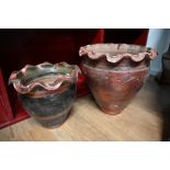 Two lustre red planters with wavy rims