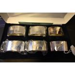 A cased set of six silver hallmarked napkin rings with booklet