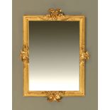 A rococo style giltwood mounted mirror, with scrolling C scroll and moulded frame.