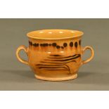A 17th/18th century pottery slip glazed loving cup. Diameter 12 cm, height 10 cm.