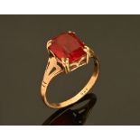 A 9 ct gold ring, set with a red coloured synthetic stone. Size M/N. 2.3 grams gross.