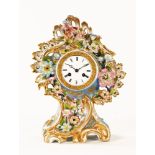 A 19th century French porcelain clock, with floral encrustations to the rococo case,