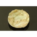 A Chinese carved jade buckle, decorated with dragons. Diameter 57 mm.