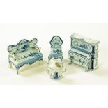 Four pieces of delft ware dolls house or cabinet furniture, settee, piano, seat and watering can.
