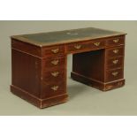 An Edwardian mahogany pedestal desk, with leatherette writing surface,