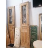 Pair of wooden doors with iron frames, one with iron frame partially glazed, height 247 cm,