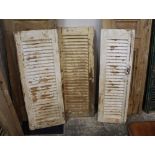 Three white painted distressed wooden louvre shutter doors, height 110 cm,