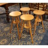 Four oak bar stools with tripod legs,