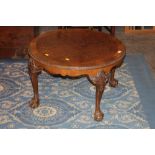 Circular walnut coffee table raised on claw and ball feet, 48 cm tall,