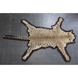 Taxidermy - A Leopard skin rug, with brown felt backing, nose to tail 7',