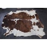 Taxidermy - A cow skin rug, length 191 cm, width across centre section 175 cm.