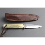 A fixed blade hunting knife with a 4 1/4" straight blade with stag antler handle and leather sheath.