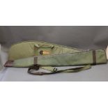 Canvas shotgun slip, together with a canvas rifle slip. Length 124 cm.