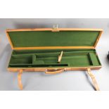 A Gunmark leather shotgun case, opening to a dark green lined interior with space for 30" barrels.