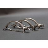 A set of six silver coloured napkin holders, in the form of a fox, hound, hare, and pig,