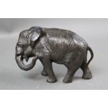 A late 19th/early 20th century bronze Asian Elephant, with tilted head. Height 8.