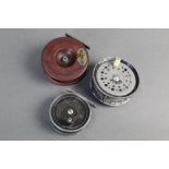 Three reels, a rainbow trout fly reel No 6-7, 2 3/4", together with another fly reel,