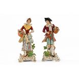 A pair of continental porcelain figures with game, raised on rococo style bases. Height 19.5 cm.