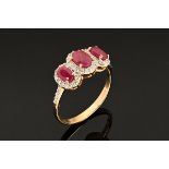 A 14 ct three stone ruby and diamond cluster ring.