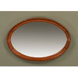 An Edwardian mahogany oval framed mirror, with bevelled glass.