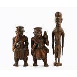A pair of African carved wooden figures, and another. Tallest 59 cm.