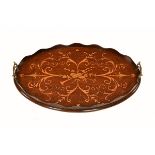 An Edwardian inlaid mahogany oval tray, with wavy gallery and brass carrying handles. Length 56 cm.