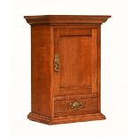 An Edwardian oak tabletop cupboard with drawer, with brass fittings.