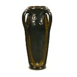 A large Art Nouveau style floor standing vase, with green mottled glaze.