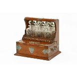 A late 19th century oak tantalus, with three decanters and plated decoration.