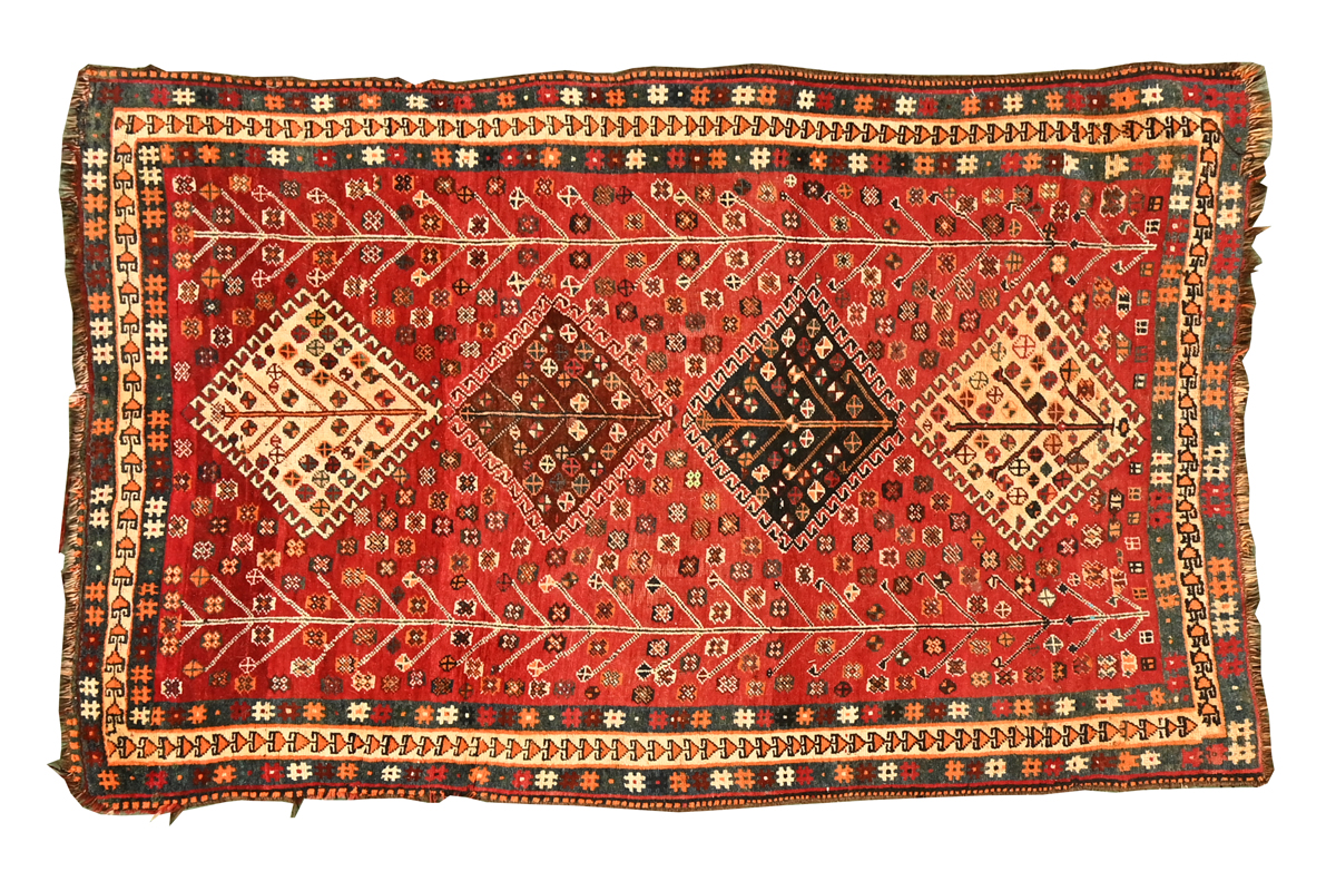 An Eastern fringed rug, with repeating diamond shape pattern to centre, principal colours beige,