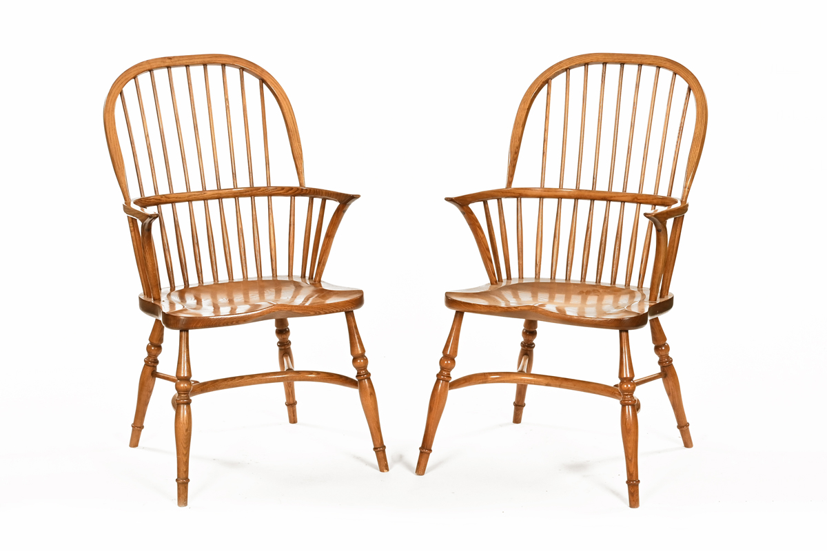 A pair of ash and elm Windsor style stick back armchairs, with solid shaped seats,