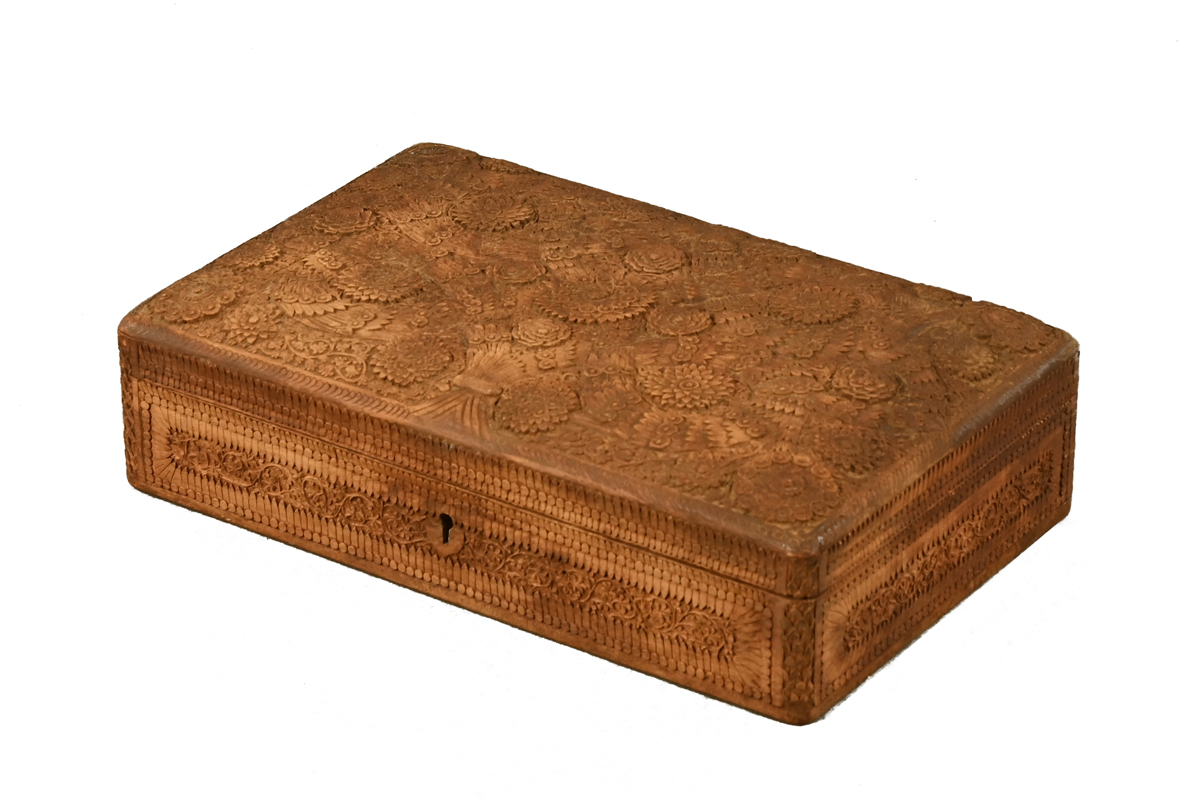 A Burmese carved teak box, decorated with repeating foliate designs and with fitted interior.