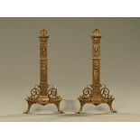 A pair of antique brass fire dogs, moulded with shells and mythical sea creatures.