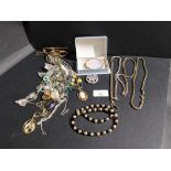 Box of costume jewellery to include a gilt metal oval brooch and bags of chains