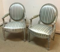 A pair of early to mid 20th Century painted spoon back salon elbow chairs in the Louis XV style
